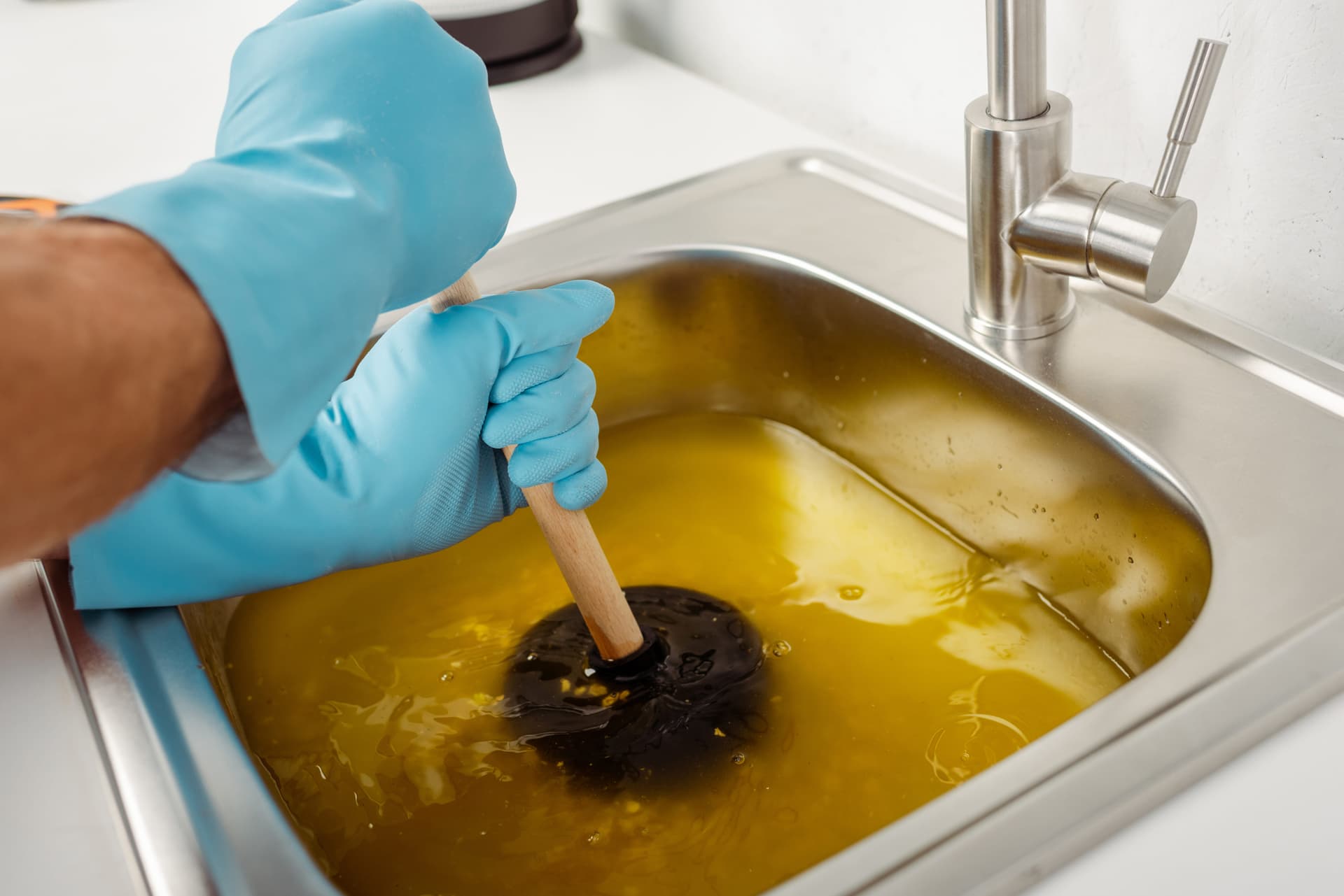 cropped-view-of-plumber-in-rubber-gloves-holding-min,jpg